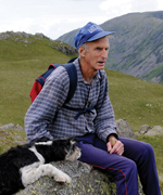 Joss, with his dog Titch, sitting on the very same rock where he sat as a boy of just five waiting for his father and the sheep to return from a gather in and around Ennerdale.